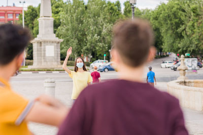 Rear view of people standing on street