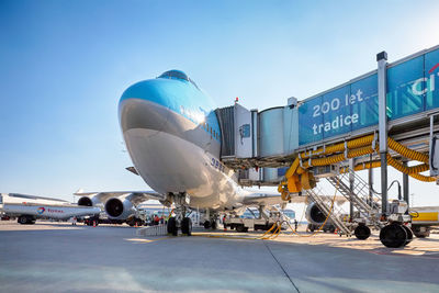 Airplane on airport runway against clear blue sky