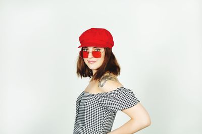 Portrait of smiling young woman against white background