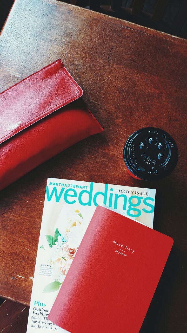 indoors, table, still life, text, communication, red, high angle view, western script, close-up, paper, no people, book, wood - material, education, absence, single object, capital letter, heart shape, pattern, empty