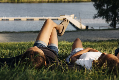 Female friends lying together on grass at summer camp