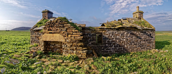 Old ruins on field against sky