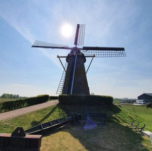 Traditional windmill on field against sky