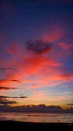 Scenic view of sea against dramatic sky during sunset