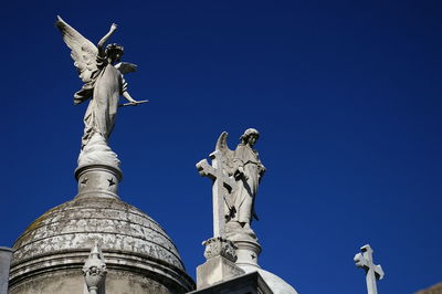 Low angle view of statue against blue sky