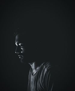 Side view of young man in darkroom