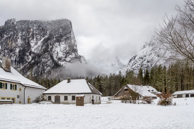 Scenic view of snow covered trees and houses against sky