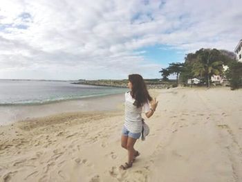 Rear view of woman walking on beach