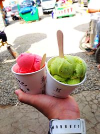 Midsection of person holding ice cream in city