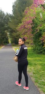 Full length of woman on road against trees