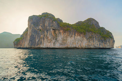 Rock formations by sea against sky