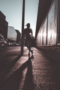 Rear view of man walking on street in city