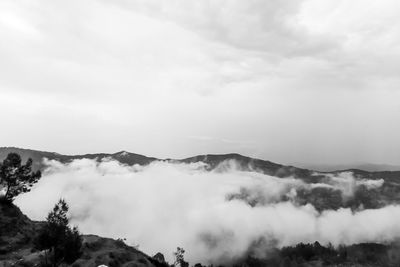 Scenic view of clouds covering mountains against sky