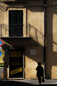 Rear view of man walking on building