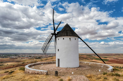 Traditional windmill on field against sky