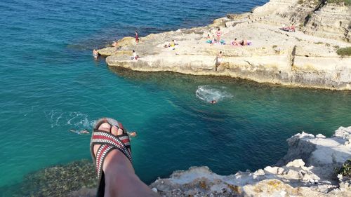 Low section of man on cliff against sea