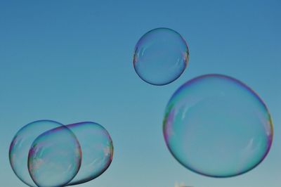 Close-up of bubbles against clear blue sky