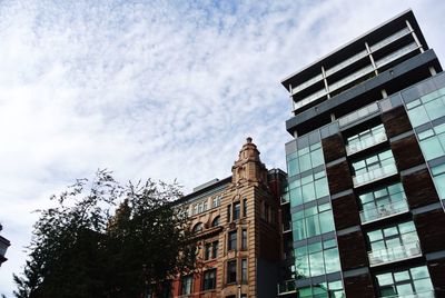 Low angle view of buildings against cloudy sky
