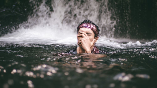 Portrait of shirtless boy swimming in water