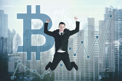 Digital composite image of businessman jumping against bitcoin symbol and city