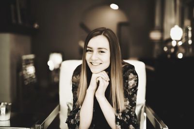 Portrait of beautiful young woman sitting on chair