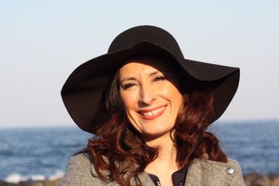 Portrait of a smiling young woman against sea