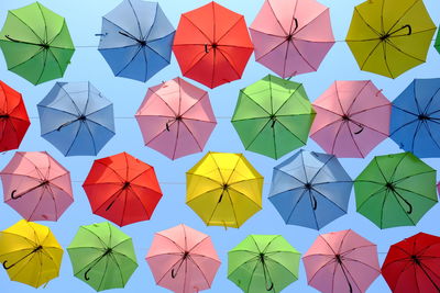 Low angle view of multi colored umbrellas against clear sky