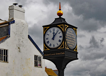 Low angle view of clock against buildings in city