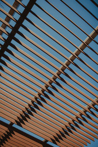 Low angle view of shade structure against clear blue sky