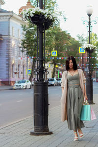 Portrait of young woman standing in city