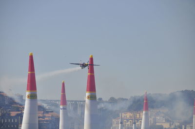 Airplane flying over city against sky