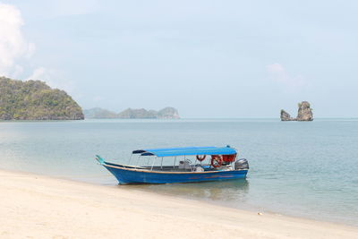 Boat moored on shore against sky
