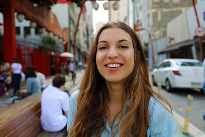 Portrait of smiling young woman in city