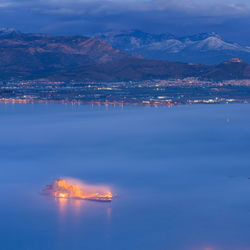 Scenic view of sea by mountains against sky