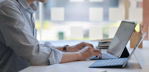 Midsection of woman using laptop