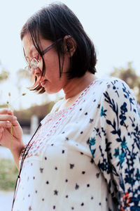 Midsection of woman holding flower. 