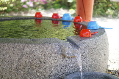 Close-up of plastic cups on drinking fountain