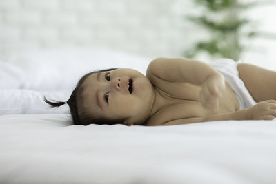 Portrait of cute baby lying on bed