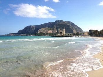 Mountain in sea against sky