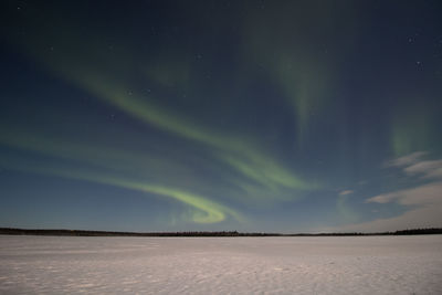 Breathtaking green dancing aurora borealis in the dark sky in sirkka, lapland, northern finland.