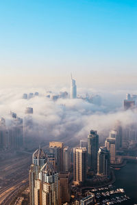Aerial view of buildings against cloudy sky