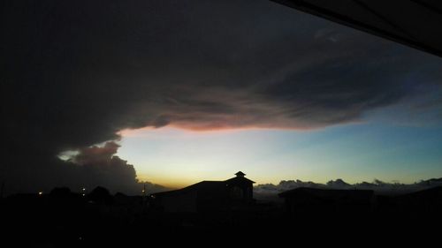 Silhouette of mountain against cloudy sky