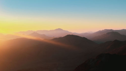 Scenic view of silhouette mountains against sky during sunset