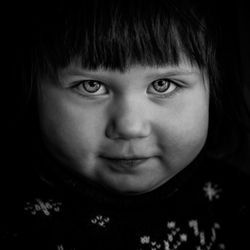 Close-up portrait of boy against black background