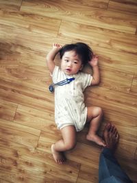 High angle view of cute baby girl on hardwood floor