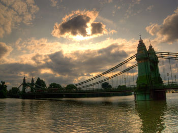 View of bridge over river against cloudy sky