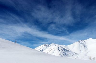 Low angle view of snowcapped mountains against blue sky