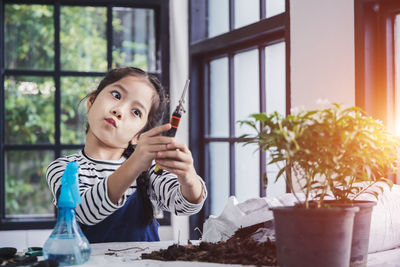 Portrait of boy sitting on table at home