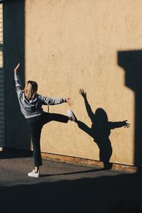Rear view of woman with shadow on wall
