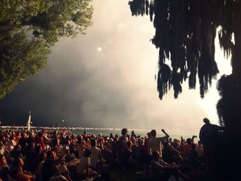 Crowd on tree against sky